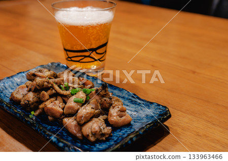 傍晚時分，人們一邊享用烤雞串和啤酒，一邊看著木桌上擺放著各種日式小吃。 133963466