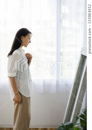 中年婦女在鏡子前檢查自己的穿著。 133963652