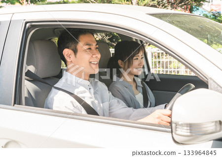 一對中年夫婦開車時開心地交談 一對中年夫婦開車時開心地交談 133964845