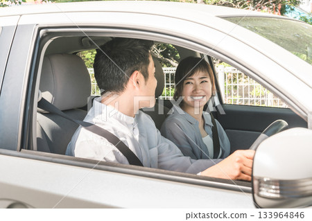 一對中年夫婦開車時開心地交談 一對中年夫婦開車時開心地交談 133964846