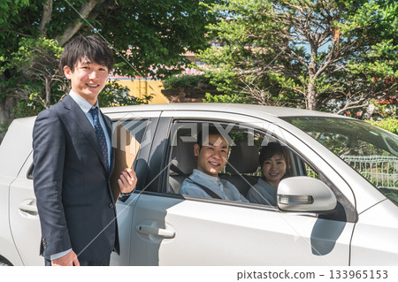 A young Asian male salesman serving customers who came to buy, assess and purchase a car 133965153