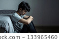 Young man feeling sad and depressed in dark bedroom 133965460