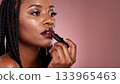 Black woman applying dark glossy lipstick 133965463
