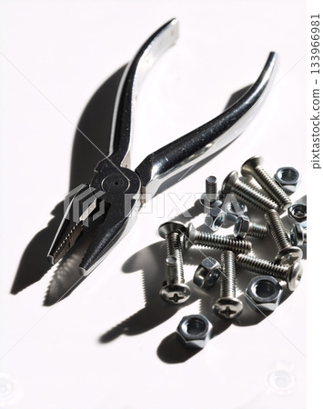 Pliers with a pile of nuts and bolts on a white background. Metal hardware and hand tools for repair and DIY projects Pliers with a pile of nuts and bolts on a white background. Metal hardware and hand tools for repair and DIY projects 133966981