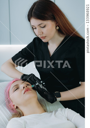 an aesthetic professional performing an injection procedure. Beauty treatment an aesthetic professional performing an injection procedure. Beauty treatment 133968921