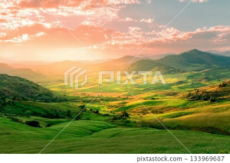 beautiful green valley with green fields with green spring grass with nive hills and mountains and scrnic colorful cloudy sunset on background of landscape 133969687