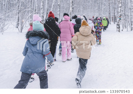 A lively group of children joyously exploring a beautiful snowcovered forest, crafting delightful winter memories 133970543