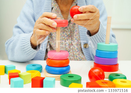 Asian elderly woman playing enhancing skill board game. Asian elderly woman playing enhancing skill board game. 133971516