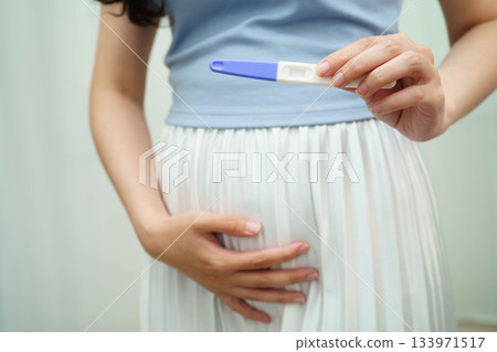 Asian holding pregnancy test for female of ovulation day, fetus, maternity, childbirth, birth control. Asian holding pregnancy test for female of ovulation day, fetus, maternity, childbirth, birth control. 133971517