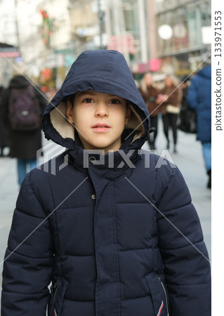Serious Portrait of a Young Boy in a Warm Winter Jacket with a Hood. Serious Portrait of a Young Boy in a Warm Winter Jacket with a Hood. 133971553