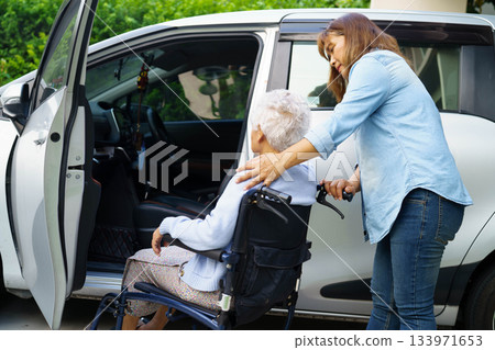 Caregiver help Asian elderly woman disability patient use wheelchair to get in car. Caregiver help Asian elderly woman disability patient use wheelchair to get in car. 133971653