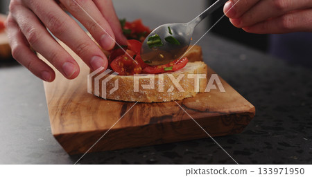 making bruschetta with cherry tomatoes and spinach leaves 133971950