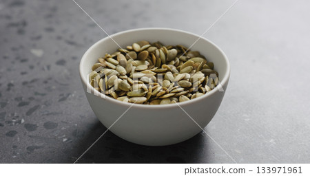 pumpkin seeds in white bowl on terrazzo countertop with copy space pumpkin seeds in white bowl on terrazzo countertop with copy space 133971961