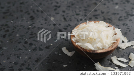 coconut chips in olive bowl on terrazzo surface 133971992