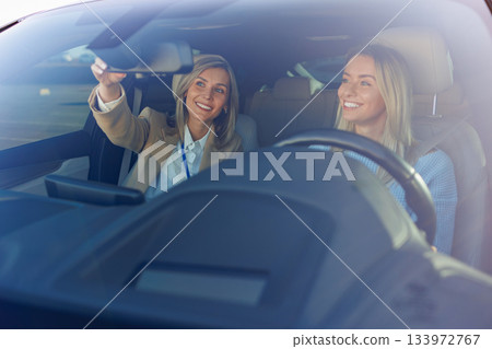 Instructor Adjusting Rearview Mirror During Driving Lesson Instructor Adjusting Rearview Mirror During Driving Lesson 133972767