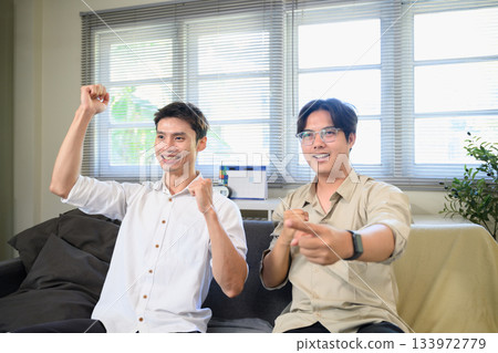 Photo Set Of Two Excited Male Friends Celebrate Watching Sports On Television At Home 133972779