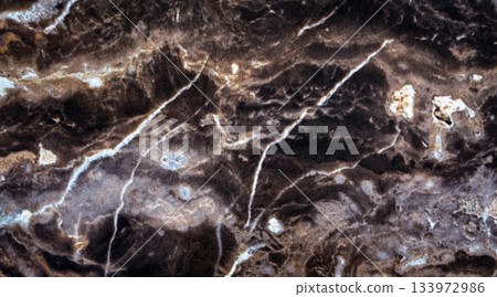 Dark brown marble texture with white natural veins. Polished stone surface showing organic patterns and elegant contrast, perfect for backgrounds, product design, architecture, or luxury interior Dark brown marble texture with white natural veins. Polished stone surface showing organic patterns and elegant contrast, perfect for backgrounds, product design, architecture, or luxury interior 133972986