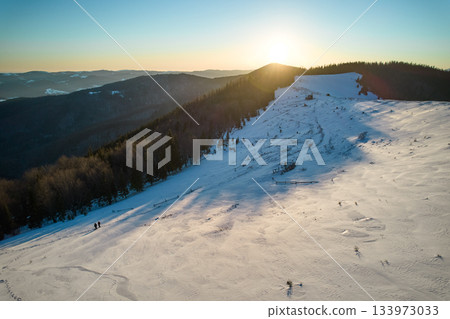 Beautiful landscape of snow covered mountains with hills, trees and morning sun on background Beautiful landscape of snow covered mountains with hills, trees and morning sun on background 133973033