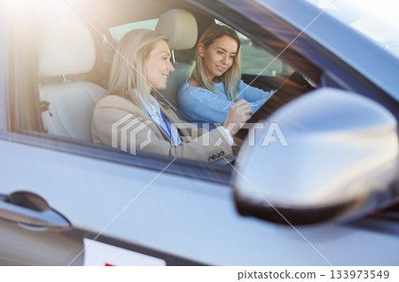 Driving Instructor Explaining Evaluation Sheet to Learner Driver Driving Instructor Explaining Evaluation Sheet to Learner Driver 133973549