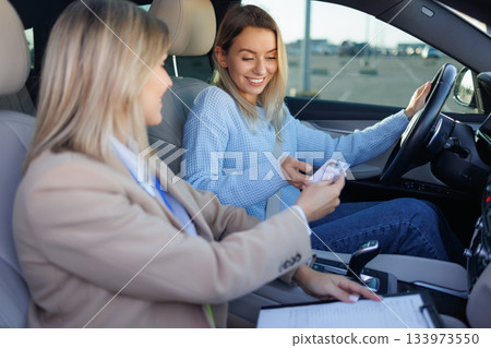 Student Driver Showing ID to Examiner Before Driving Test 133973550