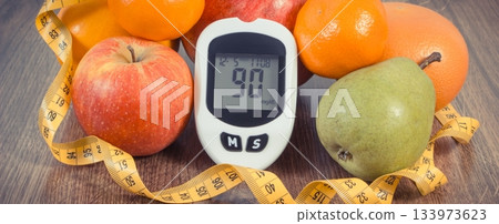 Glucometer with sugar level, fresh fruits and tape measure Glucometer with sugar level, fresh fruits and tape measure 133973623