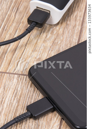 External powerbank using to charge empty battery of black smartphone External powerbank using to charge empty battery of black smartphone 133973634