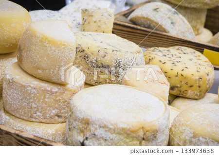 Fresh yellow or blue cheese with spices for sale on stall or in grocery shop 133973638