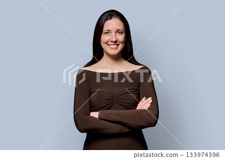 Portrait of beautiful smiling 40 years old woman posing on gray background 133974396