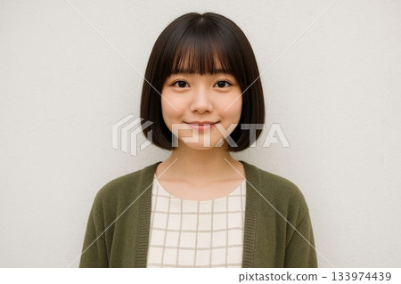 Woman with bob haircut in front of a white wall, 28 133974439