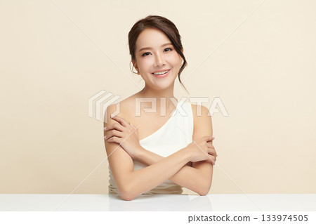A beautiful young Asian woman with clean, fresh skin against a beige background. Skincare, facial treatment, cosmetology, beauty, and spa. An elegant portrait of an Asian woman. A beautiful young Asian woman with clean, fresh skin against a beige background. Skincare, facial treatment, cosmetology, beauty, and spa. An elegant portrait of an Asian woman. 133974505
