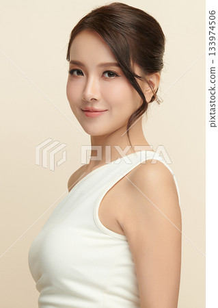 A beautiful young Asian woman with clean, fresh skin against a beige background. Skincare, facial treatment, cosmetology, beauty, and spa. An elegant portrait of an Asian woman. A beautiful young Asian woman with clean, fresh skin against a beige background. Skincare, facial treatment, cosmetology, beauty, and spa. An elegant portrait of an Asian woman. 133974506