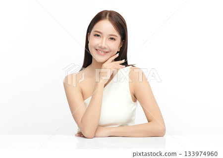 A beautiful young Asian woman with clean, fresh skin against a white background. Skincare, facial treatment, cosmetology, beauty, and spa. An elegant portrait of an Asian woman. 133974960