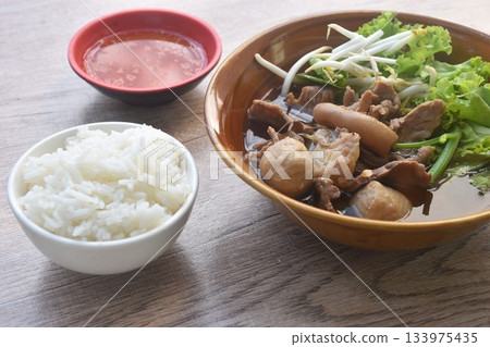 boiled braised beef meat and tendon couple organ in herb brown soup on bowl dipping spicy chili sauce eat couple with plain rice 133975435