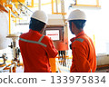 Technician monitor and command by radio to operator on job site in oil and gas industry, Worker in oil and gas industry contact to operation team to check condition of the machine. 133975834