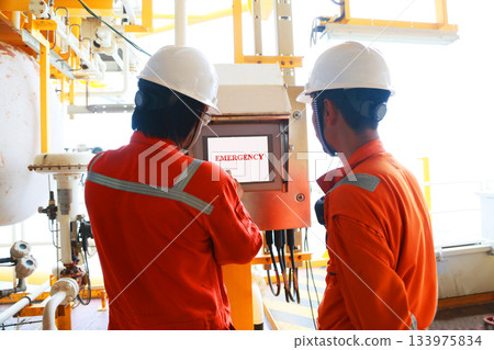 Technician monitor and command by radio to operator on job site in oil and gas industry, Worker in oil and gas industry contact to operation team to check condition of the machine. Technician monitor and command by radio to operator on job site in oil and gas industry, Worker in oil and gas industry contact to operation team to check condition of the machine. 133975834