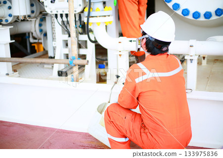 Technician monitor and command by radio to operator on job site in oil and gas industry, Worker in oil and gas industry contact to operation team to check condition of the machine. 133975836