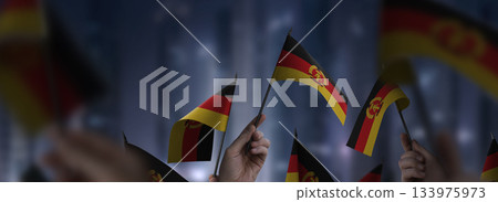 GDR flags in their hands on a blurred urban background 133975973