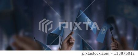 Food and agriculture organization flags in their hands on a blurred urban background 133976012