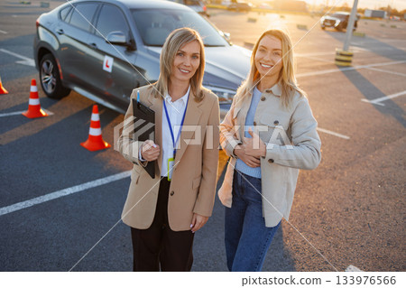 Driving instructor and student giving thumbs up after successful lesson Driving instructor and student giving thumbs up after successful lesson 133976566