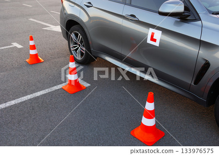 Close View of Driving School Car and Traffic Cones on Practice Ground Close View of Driving School Car and Traffic Cones on Practice Ground 133976575