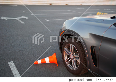 Front Wheel of Learner Car Touching Traffic Cone on Practice Course 133976632