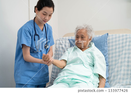 Asian doctor checking and treat elderly woman patient health in hospital. 133977426