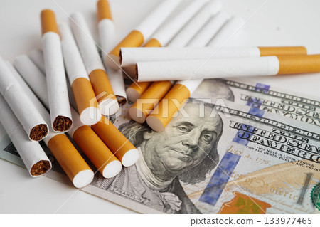 Cigarette on US dollar banknotes, cost, trading, marketing and production, No smoking concept. Cigarette on US dollar banknotes, cost, trading, marketing and production, No smoking concept. 133977465