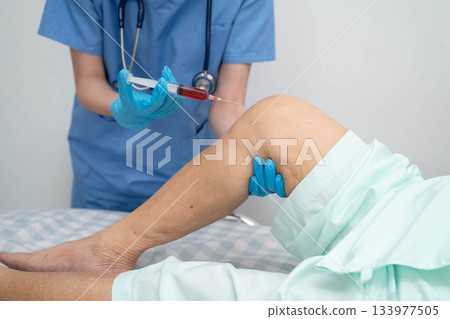 Asian doctor inject Hyaluronic acid platelet rich plasma into knee of senior woman. Asian doctor inject Hyaluronic acid platelet rich plasma into knee of senior woman. 133977505
