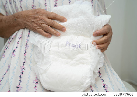 Asian senior woman patient wearing adult incontinence diaper pad in hospital. 133977605