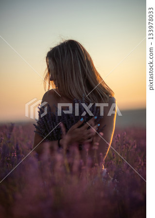 Woman lavender field sunset holding flowers romantic beauty portrait 133978033