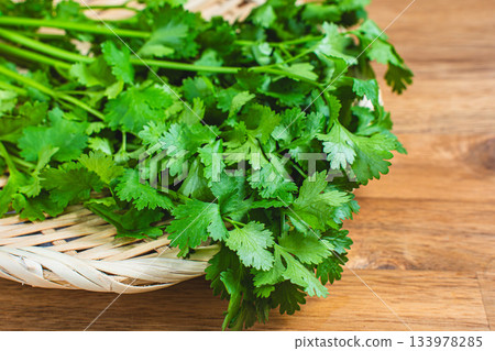 照片中，一束束香菜擺放在竹籃裡。 133978285