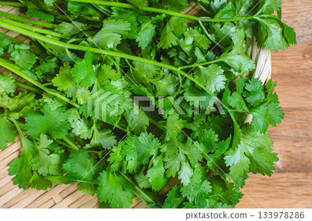 照片中，一束束香菜擺放在竹籃裡。 133978286