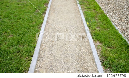 Gravel path and green grass in park 133978798