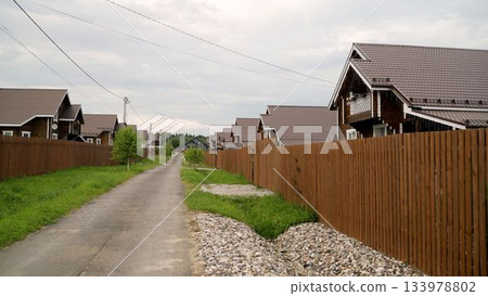 Wooden cottage village street view under cloudy sky Wooden cottage village street view under cloudy sky 133978802